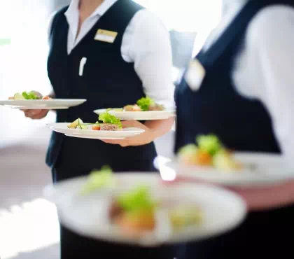 Kelnerzy trzymający talerze z daniami