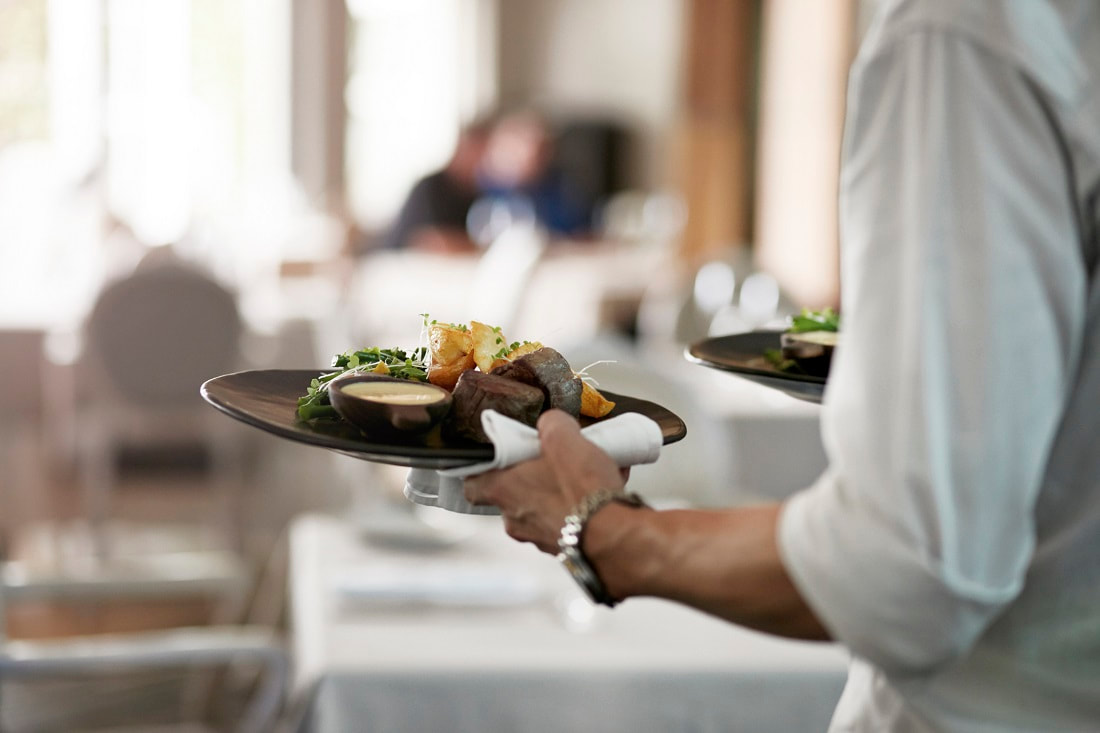 Kelner niosący dania w restauracji